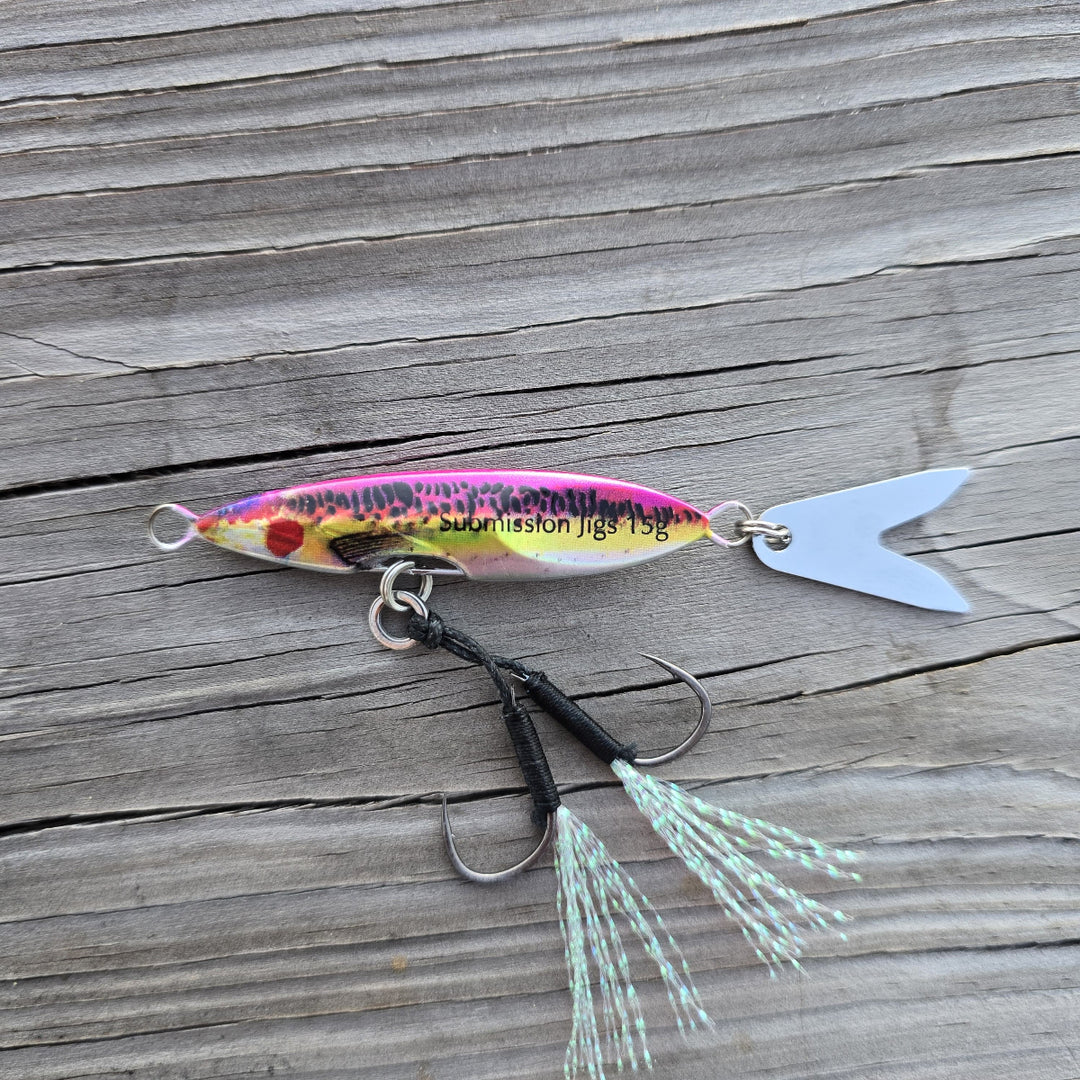 Rainbow Trout Death Blade 15g slow pitch fishing jig with assist hook and flashing fish tail blade on a wooden surface