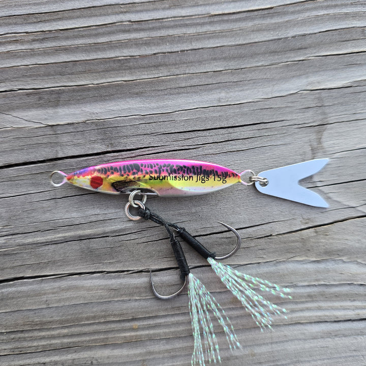 Rainbow Trout Death Blade 15g slow pitch fishing jig with assist hook and flashing fish tail blade on a wooden surface