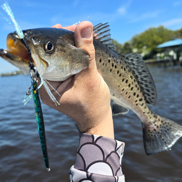 Angler holding a speckled trout caught using a Submission Fishing Ogre Jr slow pitch jig